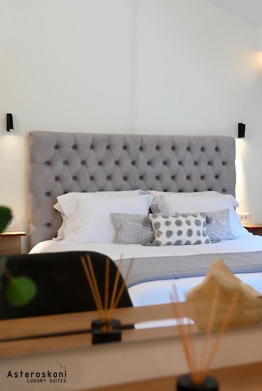 a bedroom with a bed with a tufted headboard at Asteroskoni Luxury Suites in Nafplio