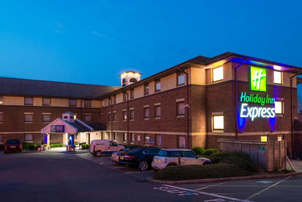 a hotel with cars parked in a parking lot at Holiday Inn Express Exeter East, an IHG Hotel in Exeter