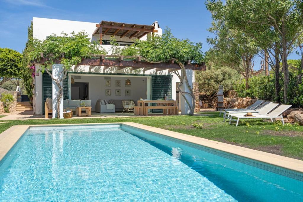 a swimming pool in the yard of a house at Villa Pepponi in Sant Lluis