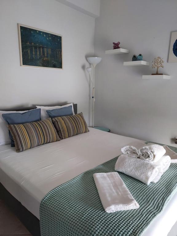 un letto bianco con due asciugamani sopra di Studio Anlia a Nea Makri