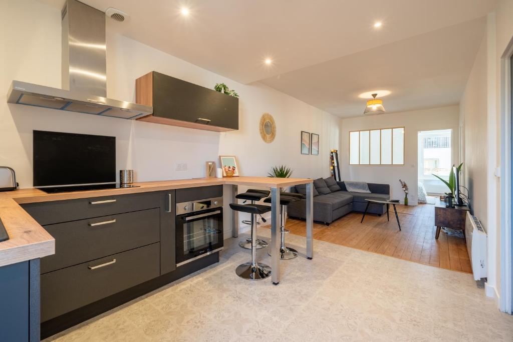 une cuisine avec une table et un salon dans l'établissement T2 cosy à deux pas de la gare, à Nantes