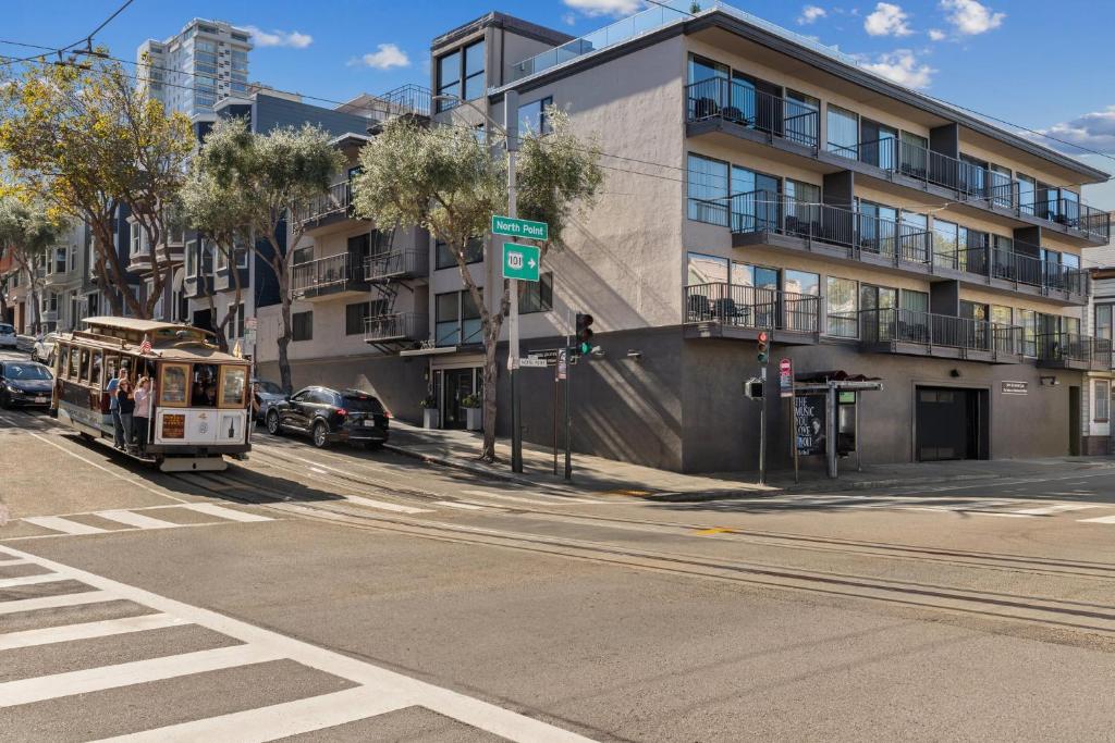 een bus rijdt door een straat naast een gebouw bij The Suites at Fisherman's Wharf in San Francisco