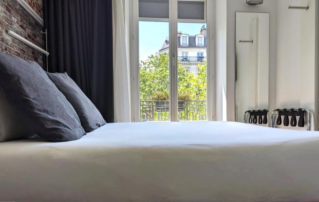 パリにあるベストウエスタン ホテル ル モンパルナスのベッドルーム(大きな白いベッド1台、窓付)