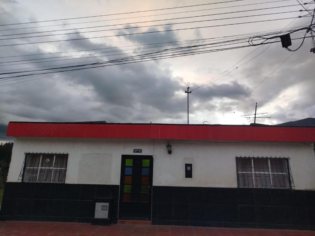un edificio bianco e rosso con tetto rosso di Hostal antaño a Duitama