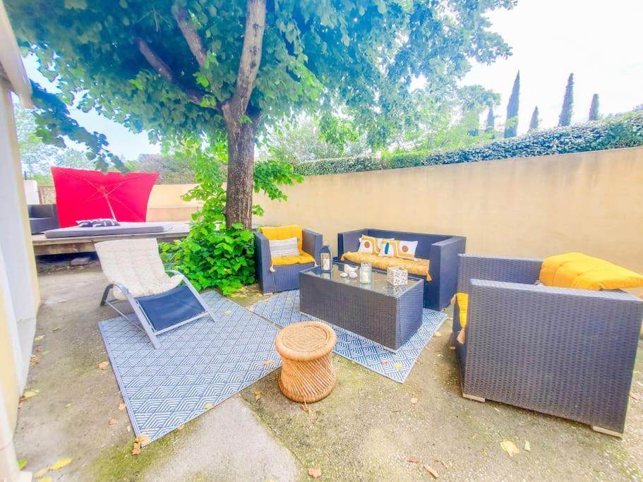 Un patio con sofás y sillas y una mesa. en Maisonnette avec extérieur avec parking, en Saint-Jean-de-Védas