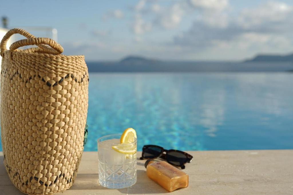 a straw bag with a drink and a glass with a slice of lemon at Blue Island Luxury Hotel Adults Only in Kaş