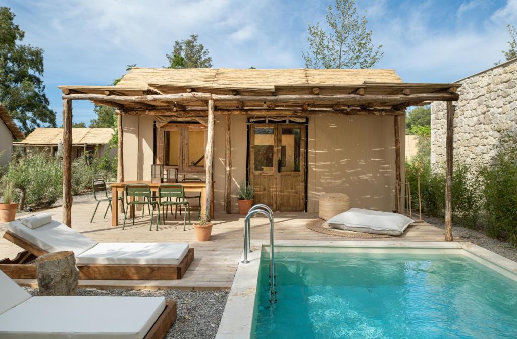 a patio with a swimming pool and a house at Ergon Beach House Nikiti in Nikiti