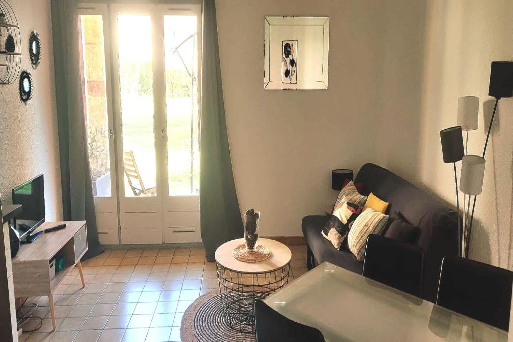 un salon avec un canapé et une table dans l'établissement Magnifique et moderne T2 - Honolulu 52, à Canet