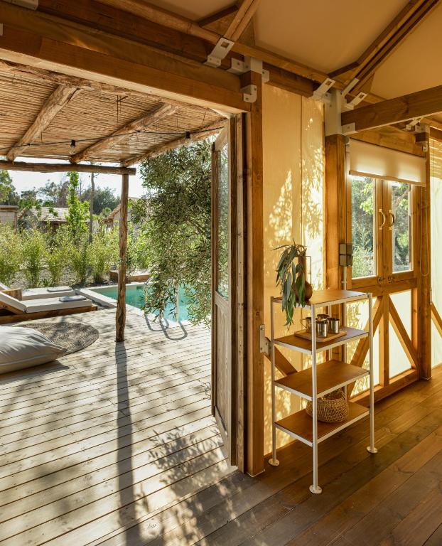 a room with a wooden floor and a glass door at Ergon Beach House Nikiti in Nikiti