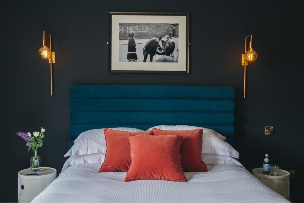 a bedroom with a blue headboard and a bed with pillows at The Porterhouse grill & rooms in Oxford