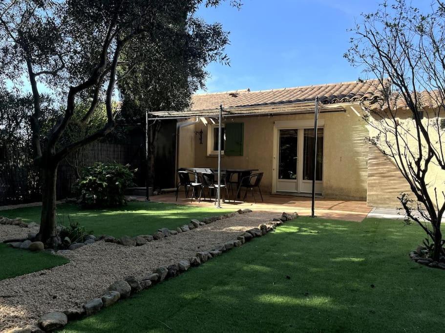 une maison avec une cour avec une table et des chaises dans l'établissement Mazet provençal, à Eyguières