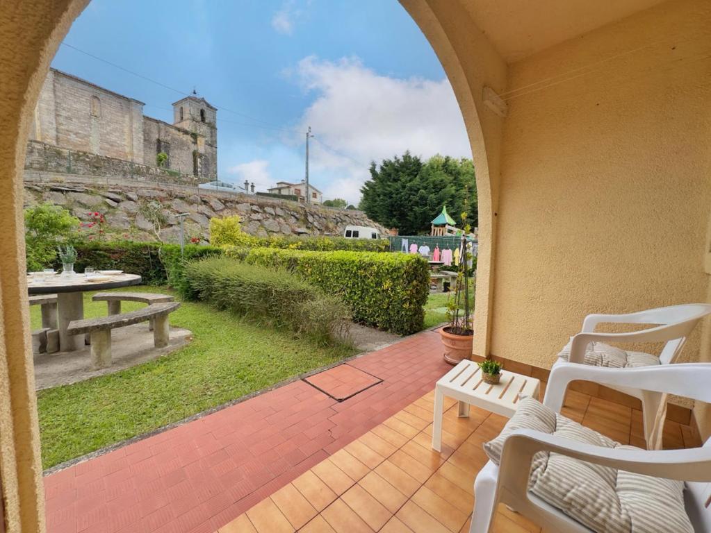 an outdoor patio with a table and chairs and a building at Casona de la Loma - 2806 in San Mamés de Meruelo