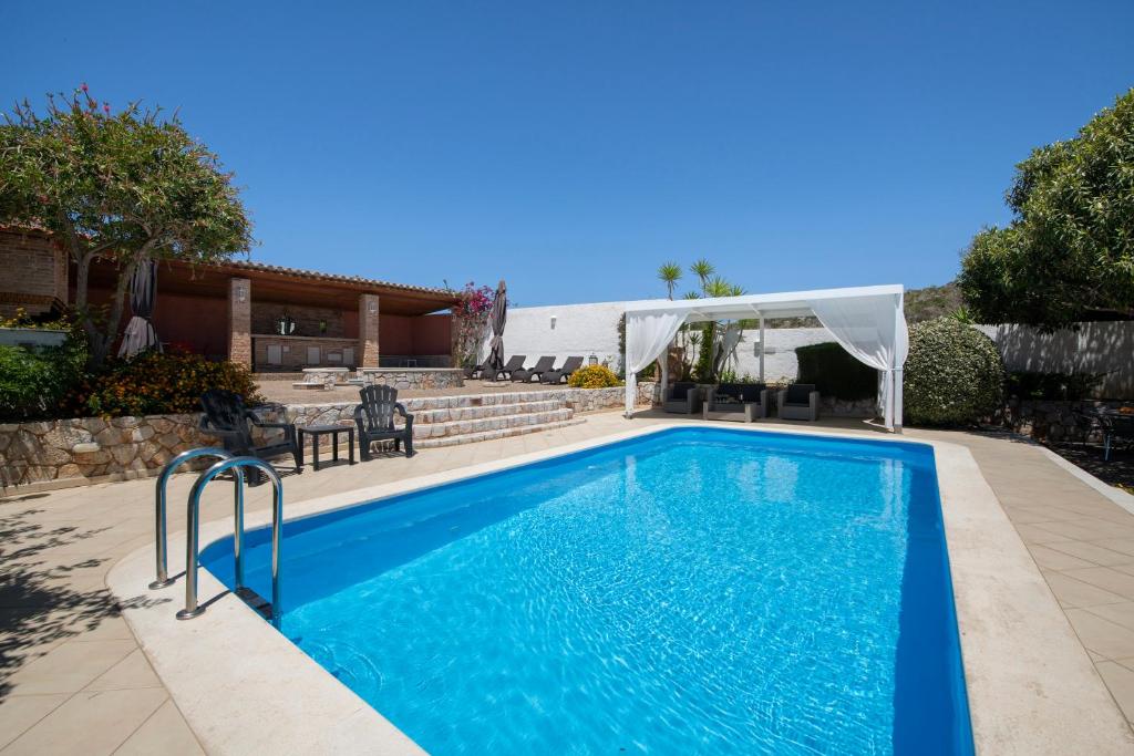 a swimming pool in a yard next to a house at Luxury Seaside Villa Plumeria ,50m to Sandy Beach, Chania in Tersanas
