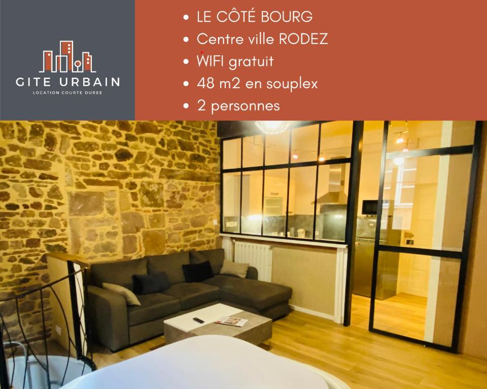 una sala de estar con un sofá y una mesa en GITE URBAIN - Côté charme, en Rodez