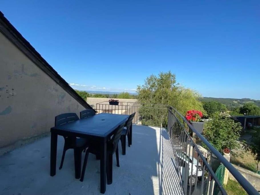 a black table on the balcony of a house at Petite maison avec terrasse in Sainte-Colombe-de-Peyre