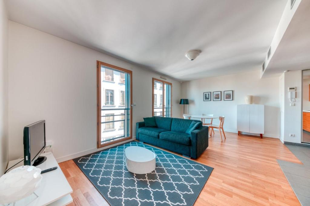 un salon avec un canapé vert et une table dans l'établissement GuestReady - Bel Appartement Croix-Rousse, à Lyon