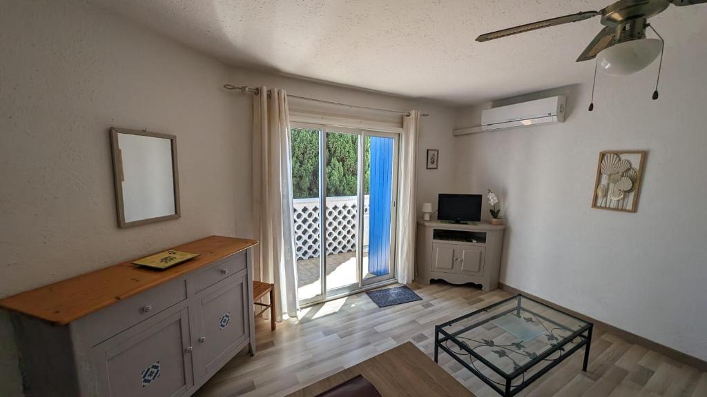 un salon avec une table, une télévision et une fenêtre dans l'établissement Jolie et Coquet Appartement T2 - Caicos 45, à Canet