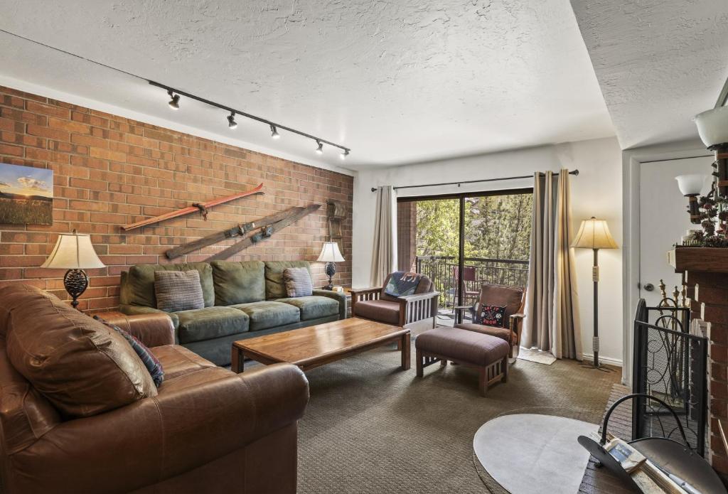 un soggiorno con un divano e un muro di mattoni di PARK STATION 121 condo a Park City