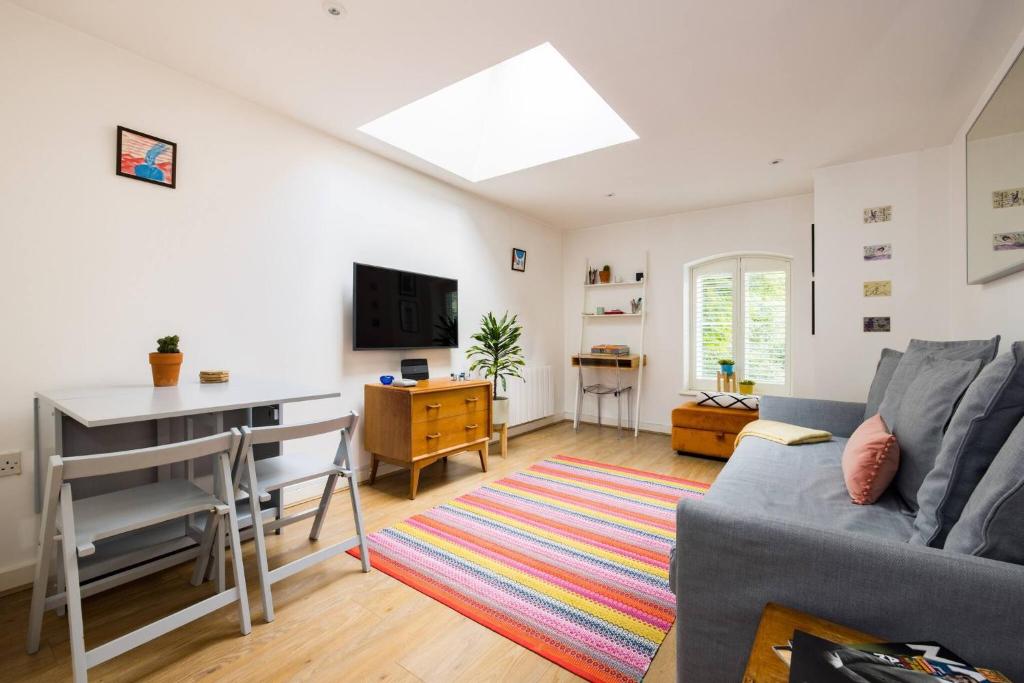 a living room with a couch and a desk at Wild Roses Serviced Apartments - City Airport in North Woolwich