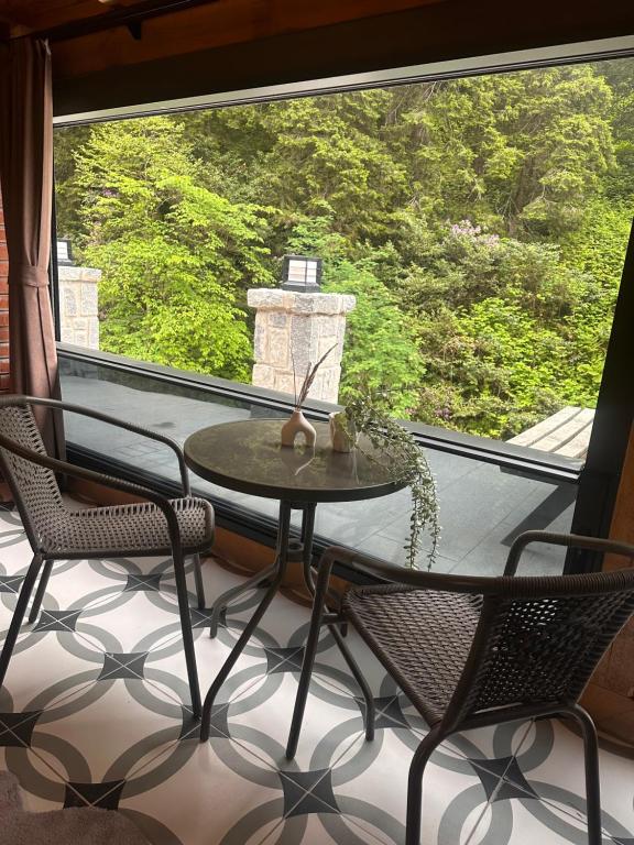 una mesa y sillas en un balcón con una gran ventana en Ayder Villa Gencal King, en Ayder