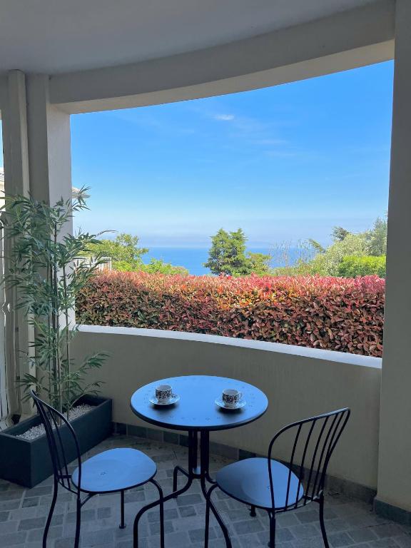une table et des chaises sur un balcon avec vue sur l'océan dans l'établissement Casa Montecristo, à Bastia