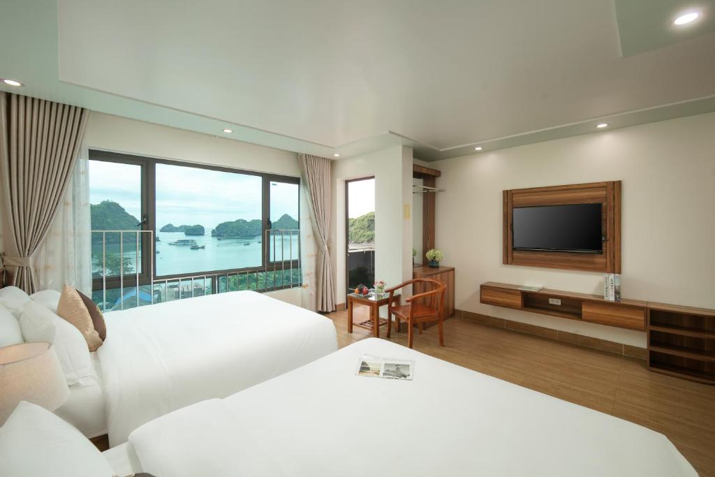 Habitación de hotel con 2 camas y TV de pantalla plana. en DUNG LAI HOTEL 173 en Cat Ba
