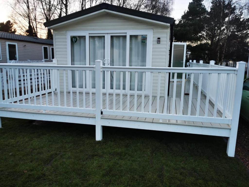 a white house with a white picket fence at Golf and Leisure Retreat in Great Yarmouth