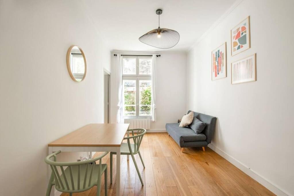 un salon avec une table et une chaise dans l'établissement Appartement centre Levallois Proche Paris, à Levallois-Perret