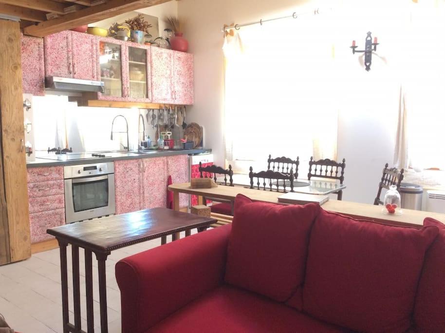 un salon avec un canapé rouge et une cuisine dans l'établissement Centre ville proche des quais, avec parking privé, à Sète