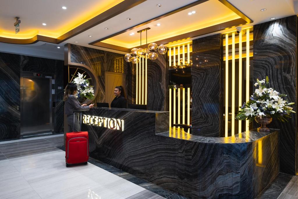 a hotel lobby with a reception desk and a red suitcase at Buke Hotel Bomonti in Istanbul