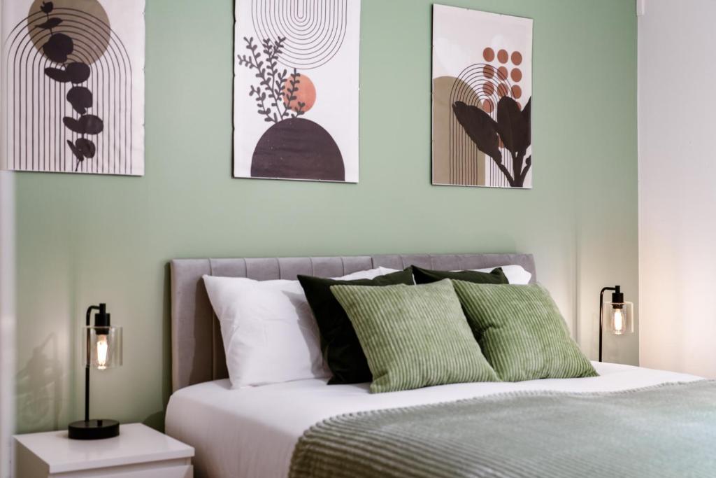 a bedroom with a bed with green and white pillows at STN - Bishops's Stortford - Free Gated Parking - Two Bed Apartment - Perfect location for Stansted Airport in Bishops Stortford