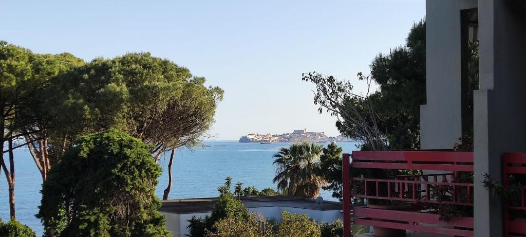 a view of the ocean from a house with a red bench at Casa OASI in Formia