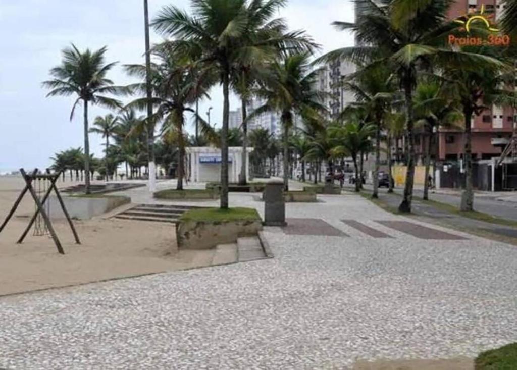 a park with palm trees and a playground at Casa com Piscina e Churrasqueira ótima localização in Praia Grande
