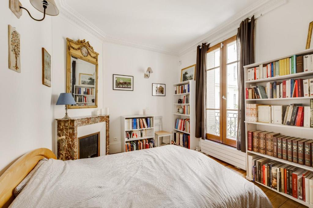 une chambre avec un lit et des étagères dans l'établissement GuestReady - Apt cosy près du Jardin des Plantes, à Paris