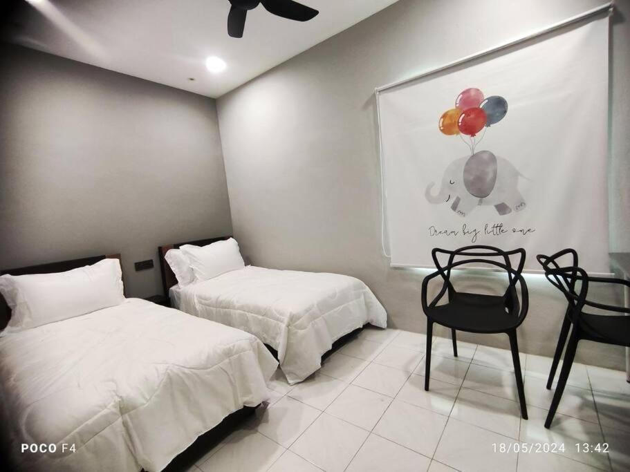 1 dormitorio con 2 camas, 1 silla y 1 pintura en MM Homestay, 5pax, Air Putih, Central Town in Kuantan, en Kuantan