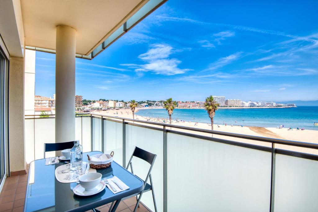 a table and chairs on a balcony with a view of the beach at Lola in L'Escala