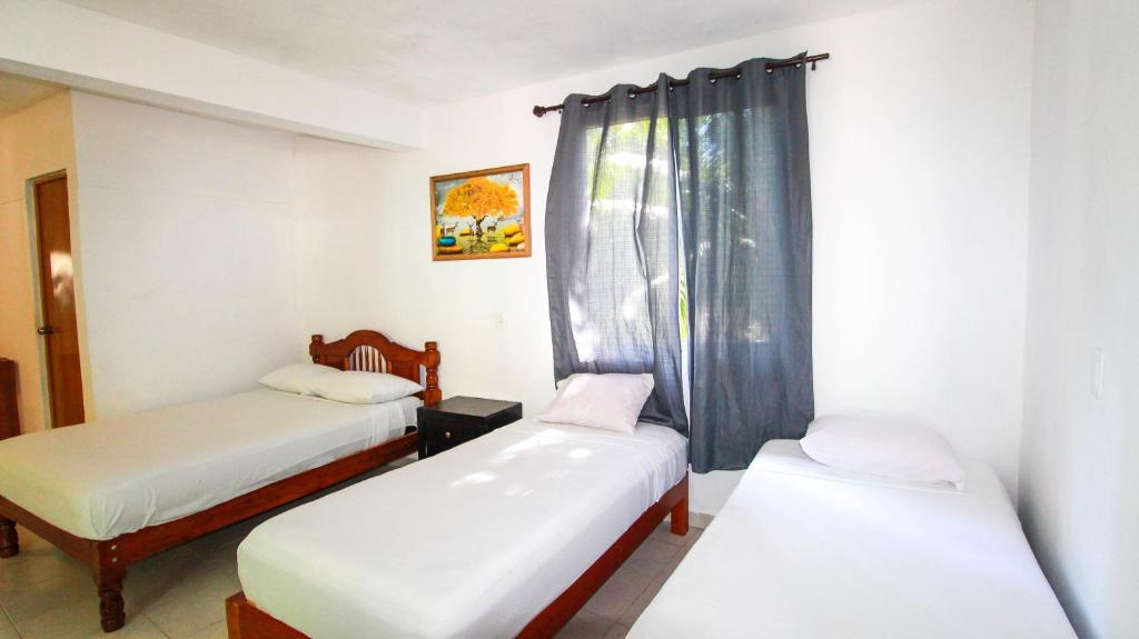 巴卡拉爾的住宿－Hotel Vias Maya Bacalar，客房设有两张床和窗户。