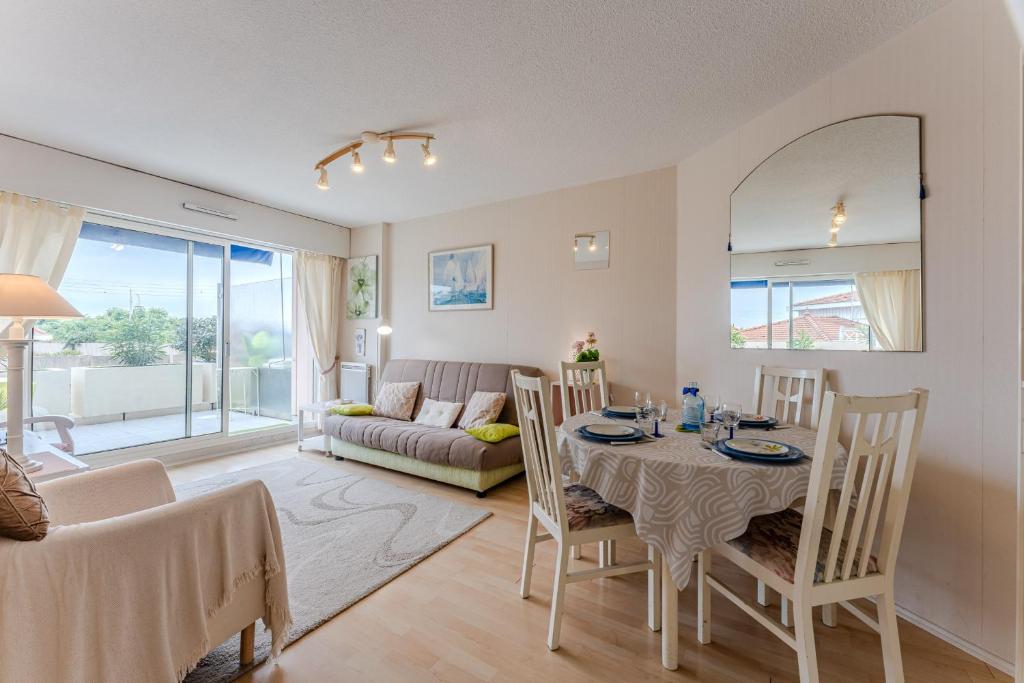 un salon avec une table, des chaises et un canapé dans l'établissement Appartement Barca - Welkeys, à Arcachon