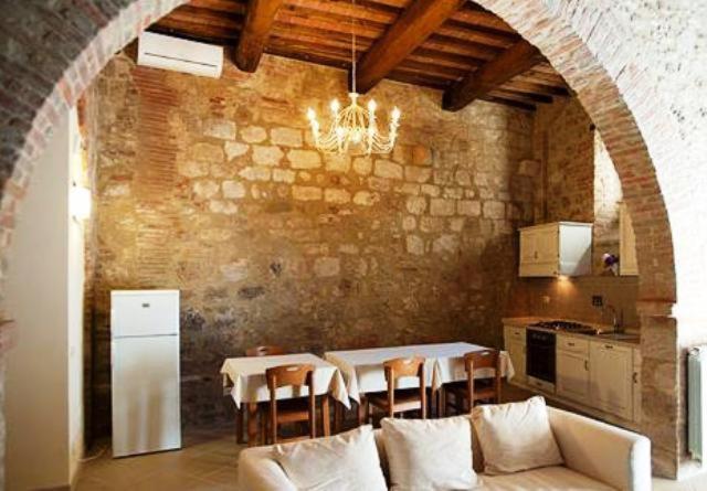un soggiorno con divano e tavolo con sedie di Arnolfo B&B a Colle Val D'Elsa