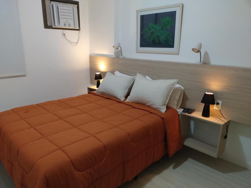 una camera con un letto e una coperta arancione di Ipanema beach - Show de apart a Rio de Janeiro