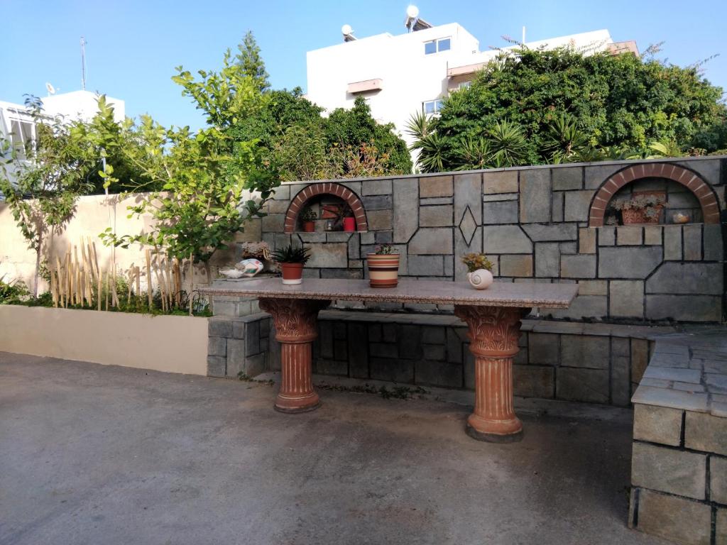 a stone wall with a table with potted plants on it at Kuburno House - Spacious - close to the beach apartment in Kos Town