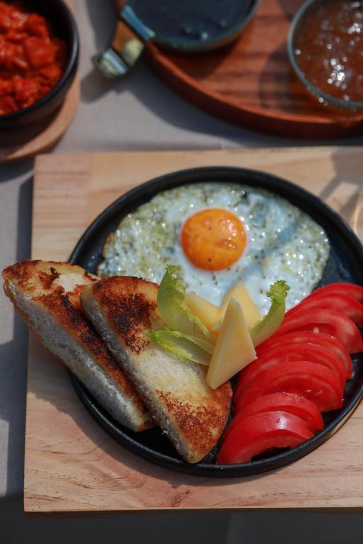 a plate of breakfast food with eggs and peppers and toast at Hotel Thethi in Theth