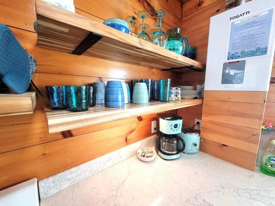 a kitchen with wooden walls and shelves with blue bowls at Sea & Sun Cottage #1 in Hampton