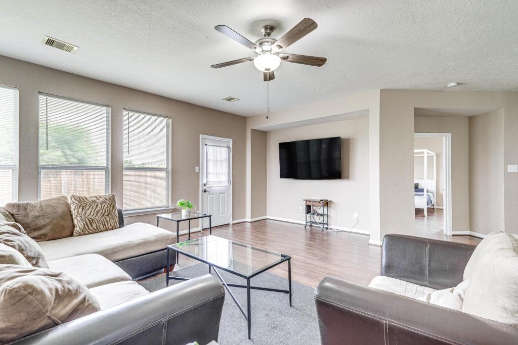 a living room with two couches and a flat screen tv at Houston Retreat with Pool Access and Fenced-In Yard! in Houston