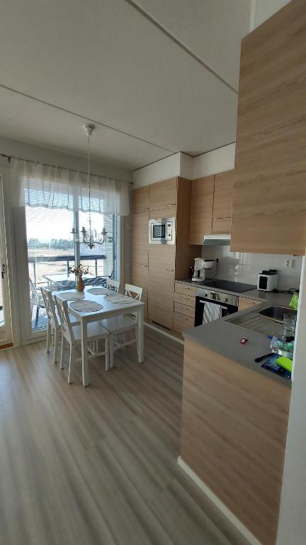 eine Küche mit einem weißen Tisch und Stühlen in einem Zimmer in der Unterkunft Meritähti 204 in Kalajoki