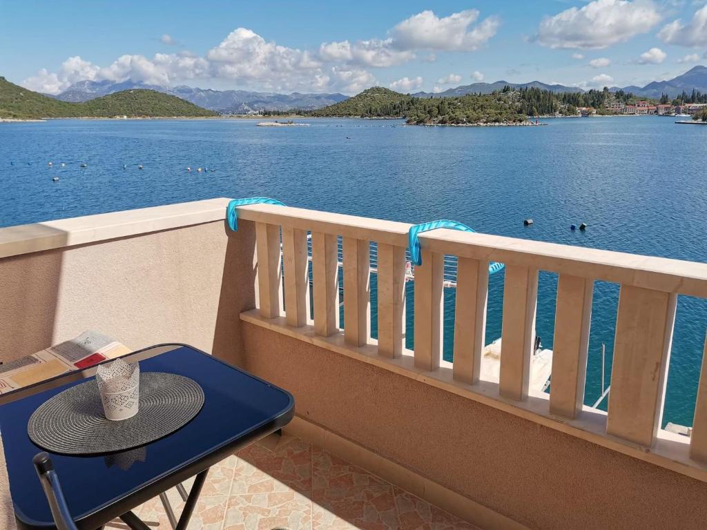 een tafel op een balkon met uitzicht op het water bij Apartments Vale in Blace