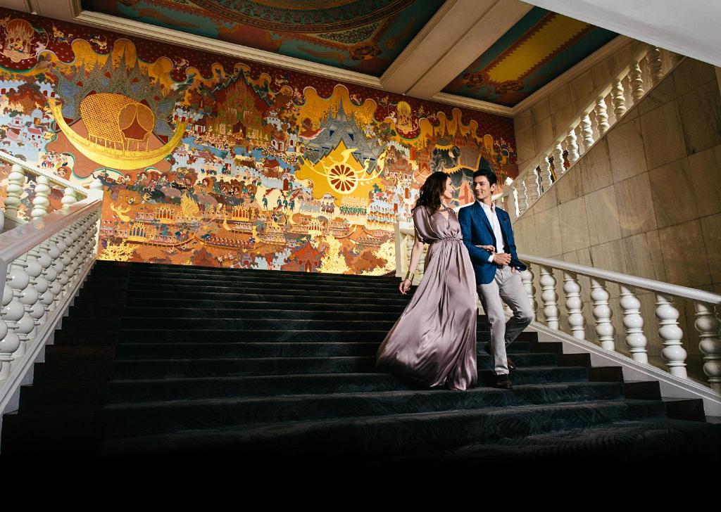 Ein Mann und eine Frau gehen die Treppe hinunter in der Unterkunft Anantara Siam Bangkok Hotel in Bangkok