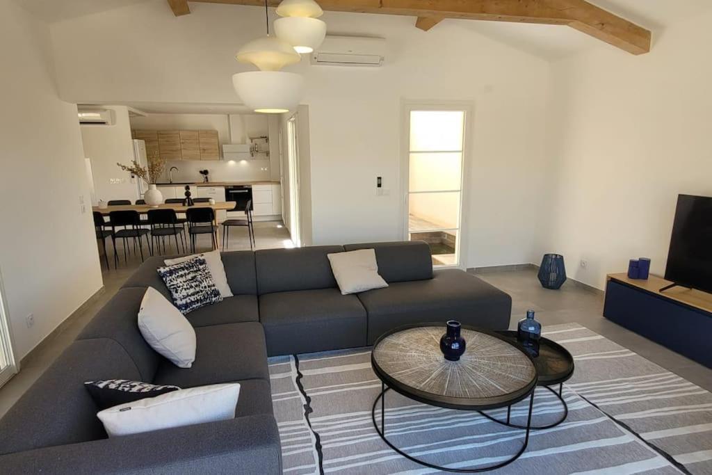 un salon avec un canapé et une table dans l'établissement 300 M de la plage, piscine Clim, wifi, à Grimaud