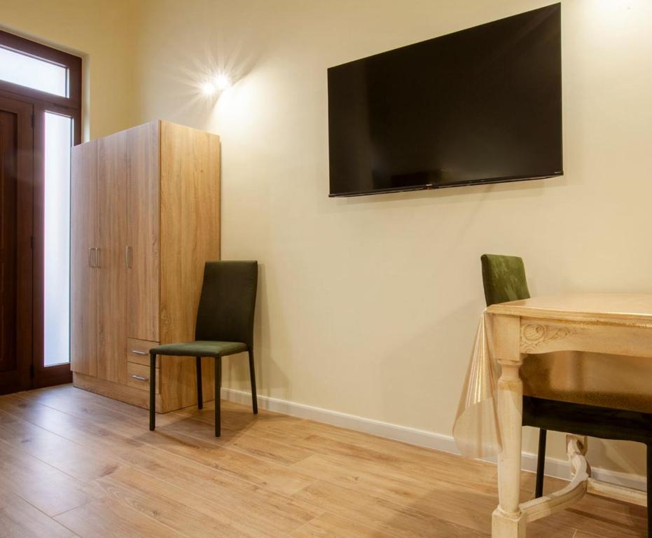 a room with two chairs and a desk with a television on the wall at Dimora Moscato Reale in Trani
