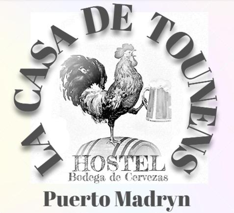 a sign with a rooster sitting on top of a barrel at Hostel La Casa de Tounens in Puerto Madryn